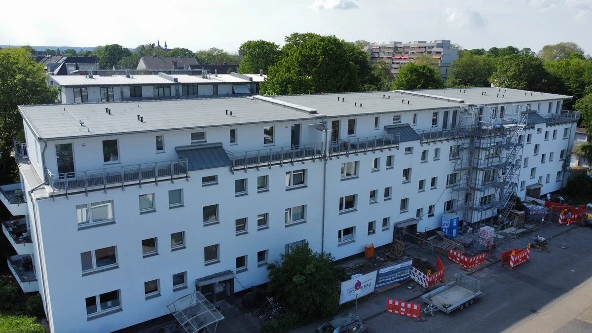 Mehrfamilienhaus mit neu aufgestocktem Geschoss und Gerüst, Projekt der UPGANGBAU GmbH
